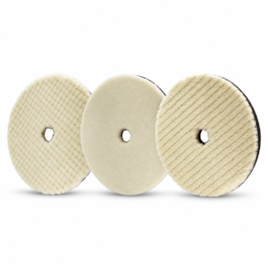 Three cream short-pile wool polishing pads with textured faces and center holes on a white background